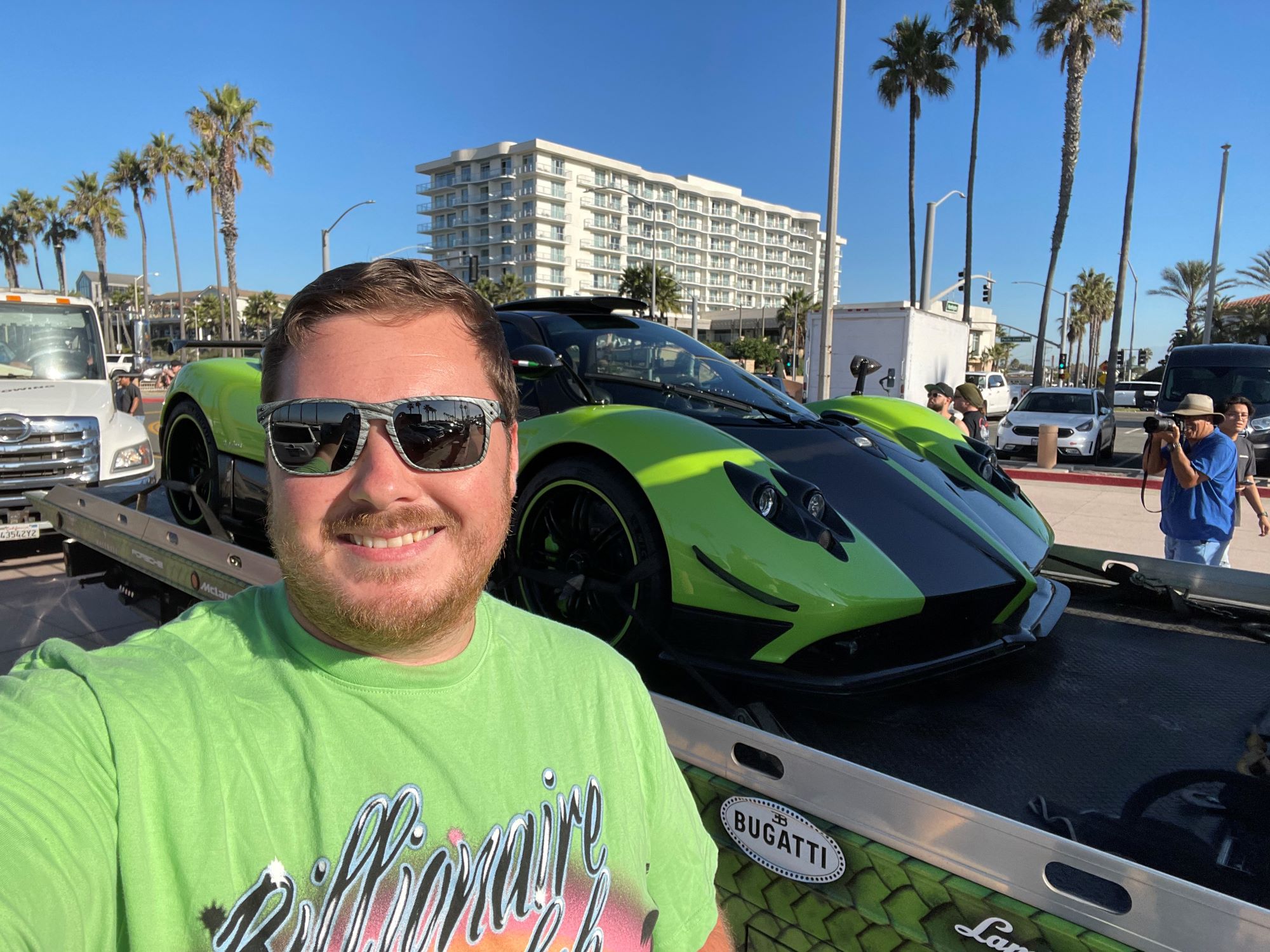 Man standing next to a green and black sports car.